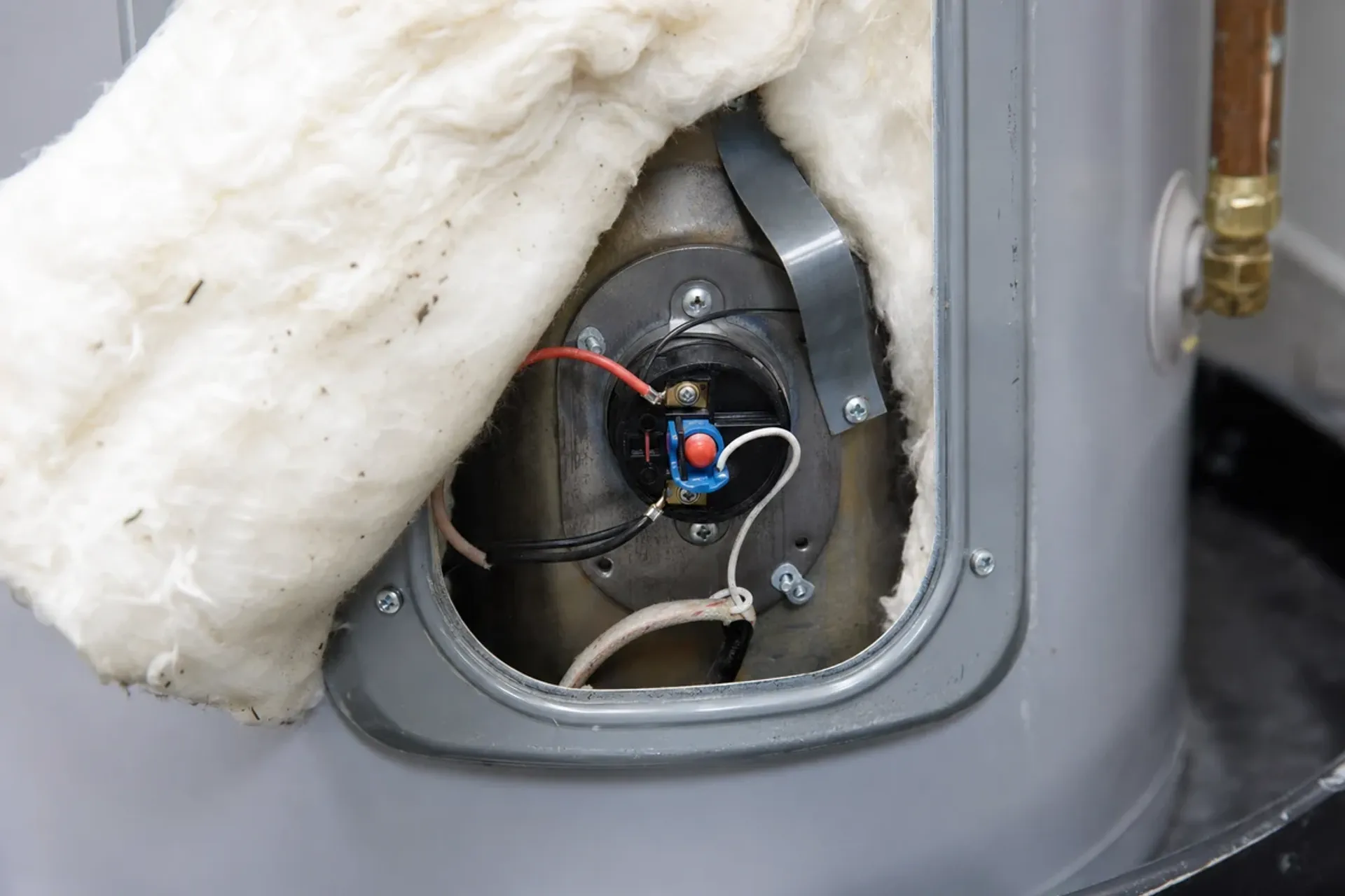 Electric water heater repair in Orange County, upper access panel off with thermostat and reset visible