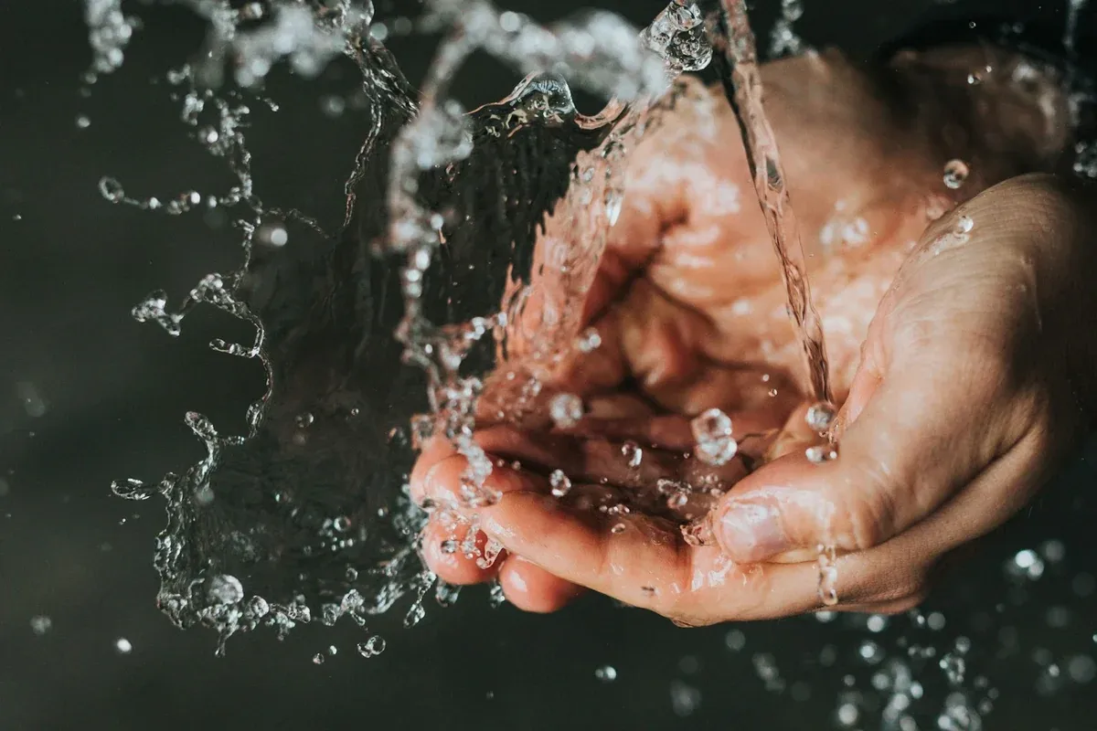 No hot water: a hand under a running tap in an Orange County home